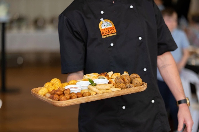 Golden Roast chef serving a platter of hot finger food